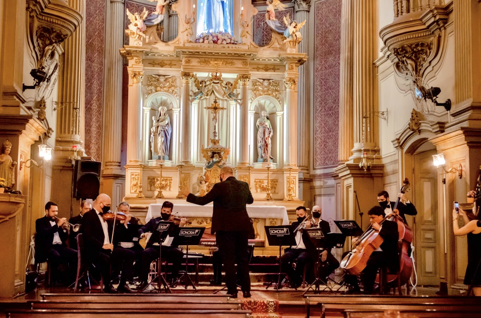 Orquestra de cordas e sopros em cerimônia de igreja